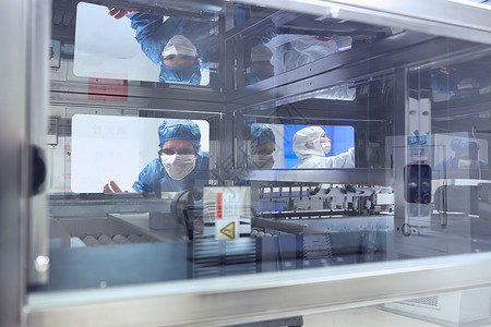 男工人在灵活电子厂清洁室通过制造机器窗口查看高清图片