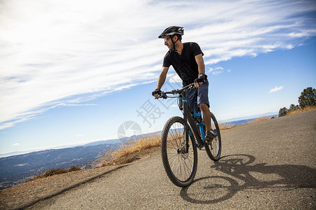 美国加利福尼亚州海湾地区山年轻的男山地自行车手从乡村道路眺望风景图片