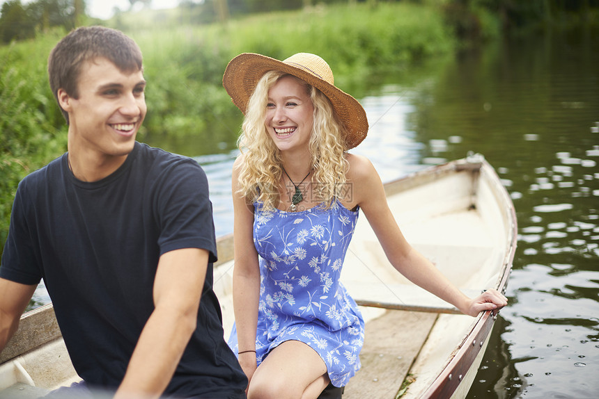 在农村河上划船的年轻夫妇图片