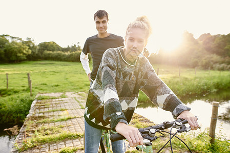 在河脚桥骑自行车的年轻夫妇肖像图片