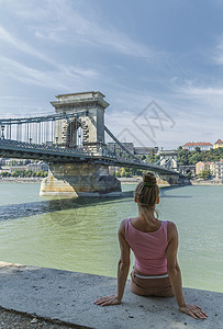 年中成妇女观看匈牙利布达佩斯多瑙河上链桥高清图片