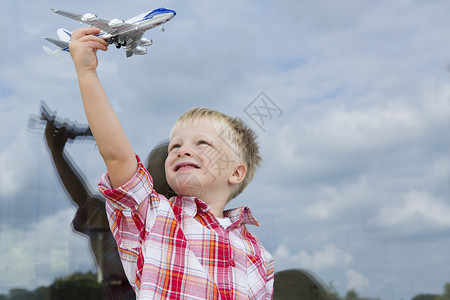 男孩把玩具飞机放在家门窗前图片