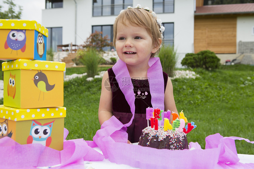 花园里有生日蛋糕和粉红丝带的女幼儿肖像图片