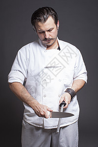 中成年男厨师刀磨的片场肖像图片