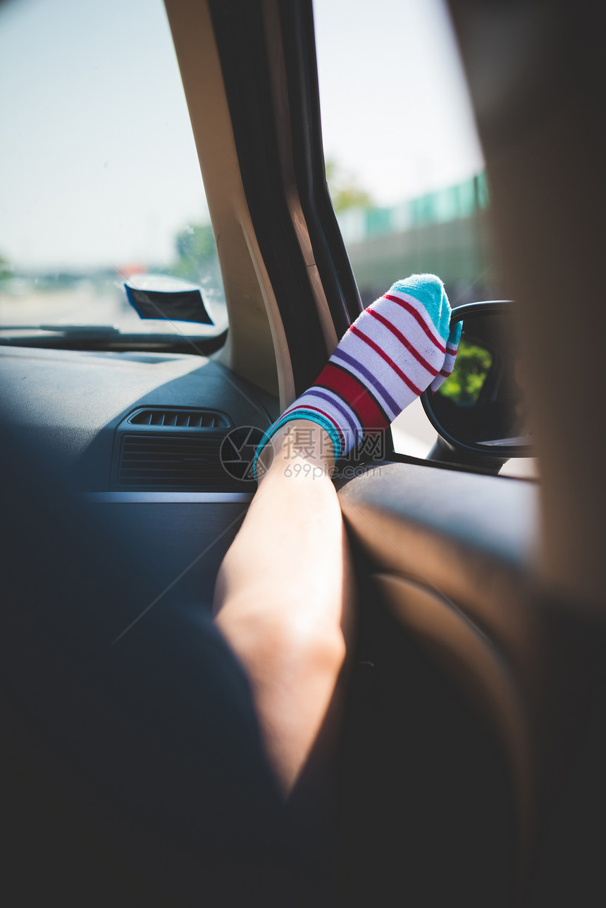 车窗上长着彩色条纹袜子的腿图片