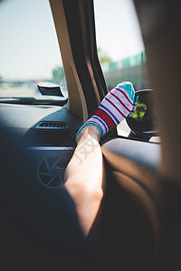 车窗上长着彩色条纹袜子的腿图片