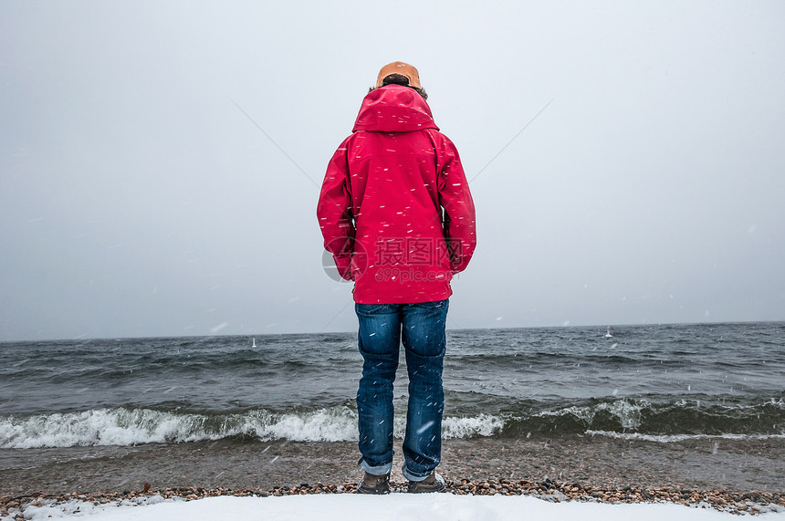 身穿红色大衣看海洋的年轻男子全长后方视线图片