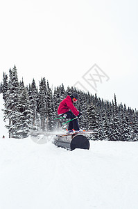 加拿大不列颠哥伦比亚省惠斯勒地形公园滑雪者在管状障碍物上滑行的侧视图图片