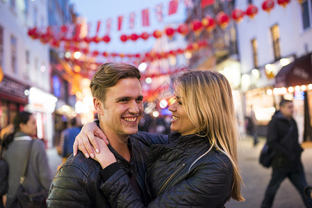 晚上在唐人街上逛街的年轻夫妇图片