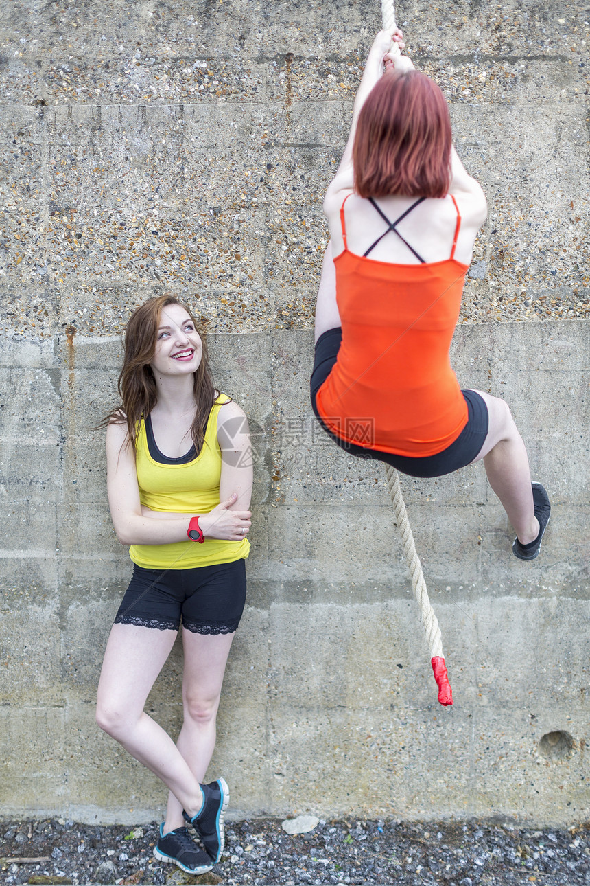 年轻女性用绳子爬墙锻炼图片