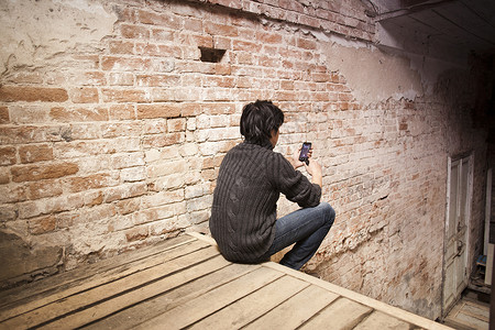 坐在台阶上看手机的中成年男子图片