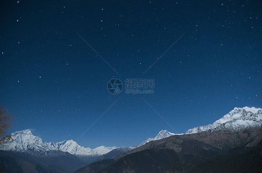 尼泊尔星夜天空下雪顶的山脉图片