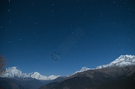 尼泊尔星夜天空下雪顶的山脉图片