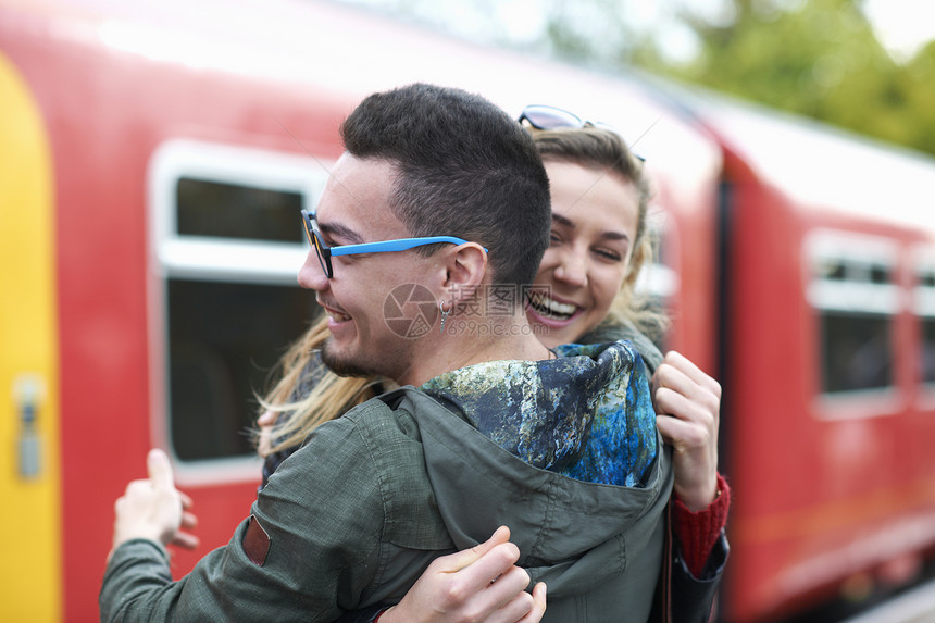 异地恋情侣在火车站满脸笑容拥抱在一起图片