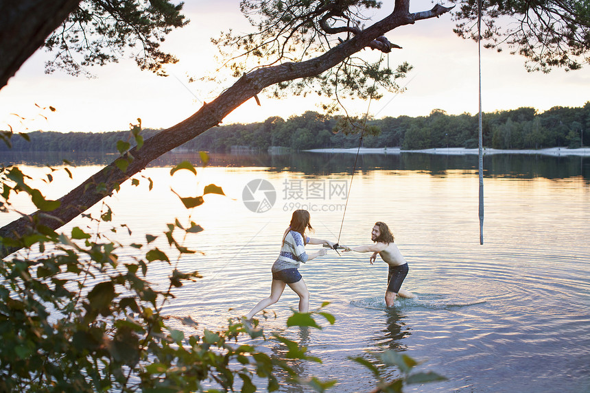 在湖边玩耍的年轻夫妇图片