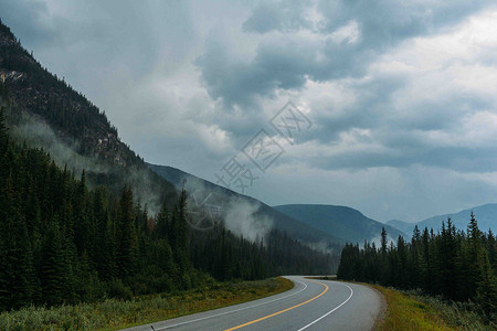 加拿大阿尔伯塔省班夫公园冰碛湖空旷公路和雾蒙蒙山脉图片