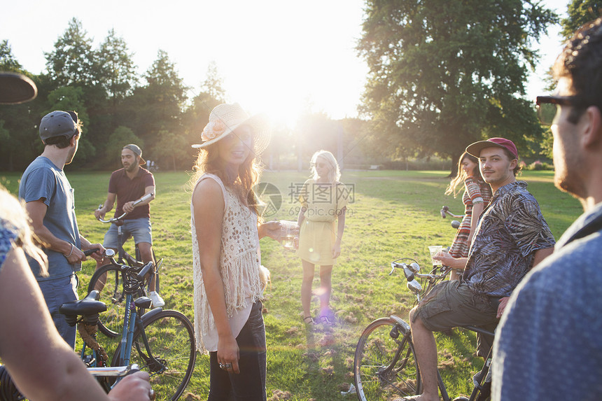 日落时骑自行车来到公园的成人团体图片