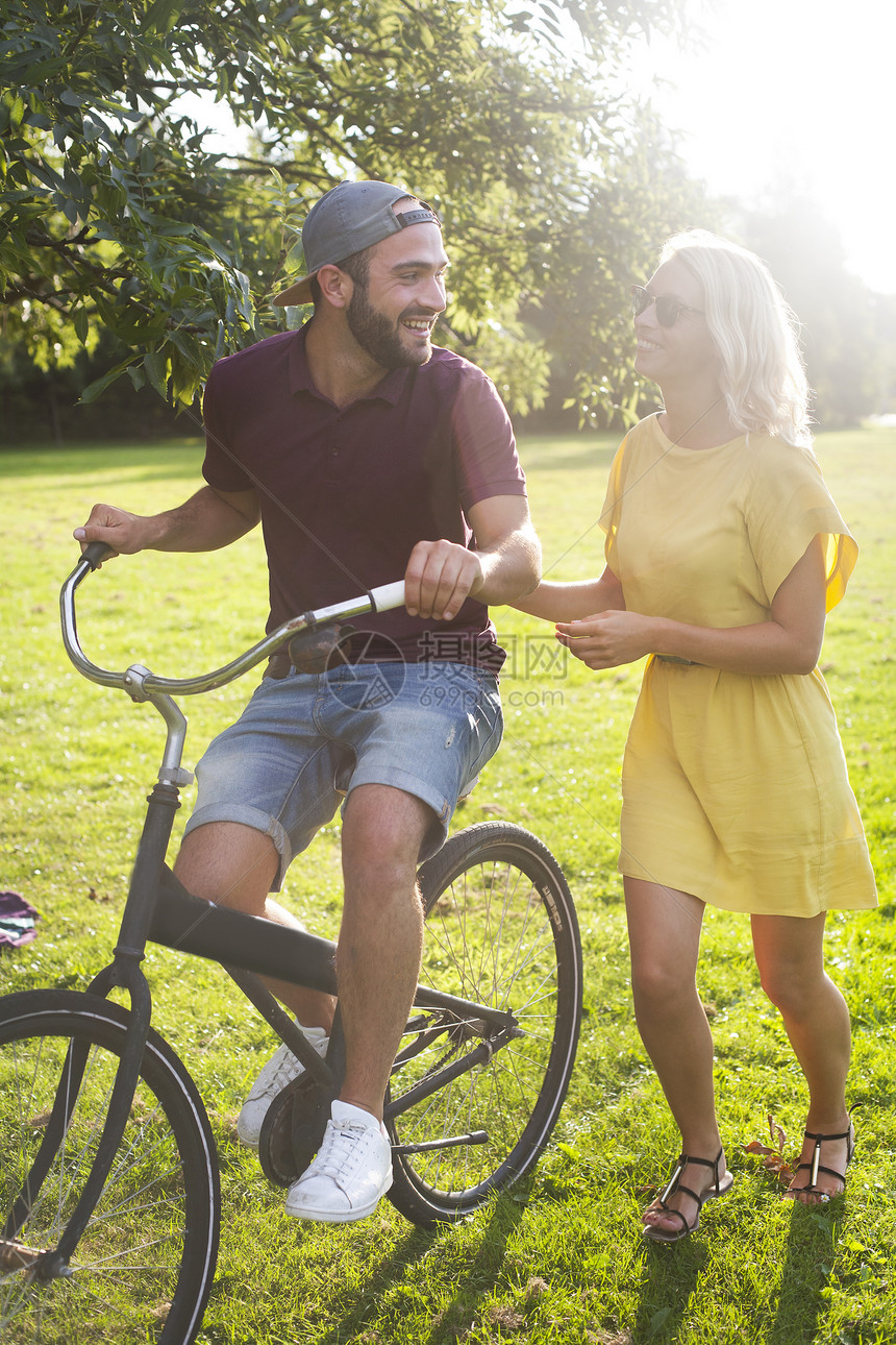 在日光公园骑自行车的年轻夫妇图片