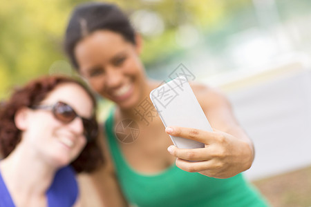 年轻女子使用智能手机自拍图片
