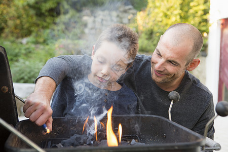 成人中年男子和儿在花园烧烤图片