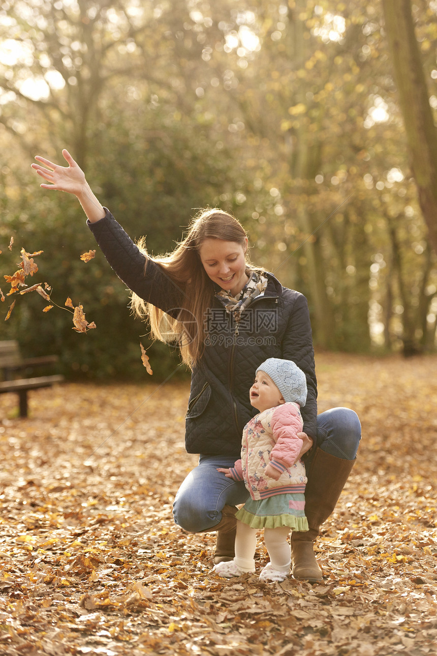 成年妇女和小孩在公园看秋叶图片