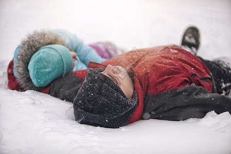躺在雪地上的男孩和女孩图片