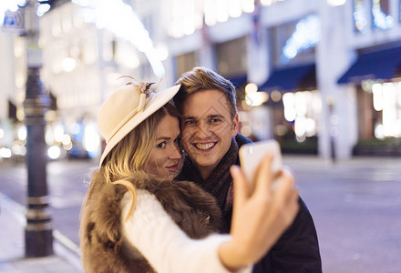 年轻夫妇在圣诞节用手机自拍图片