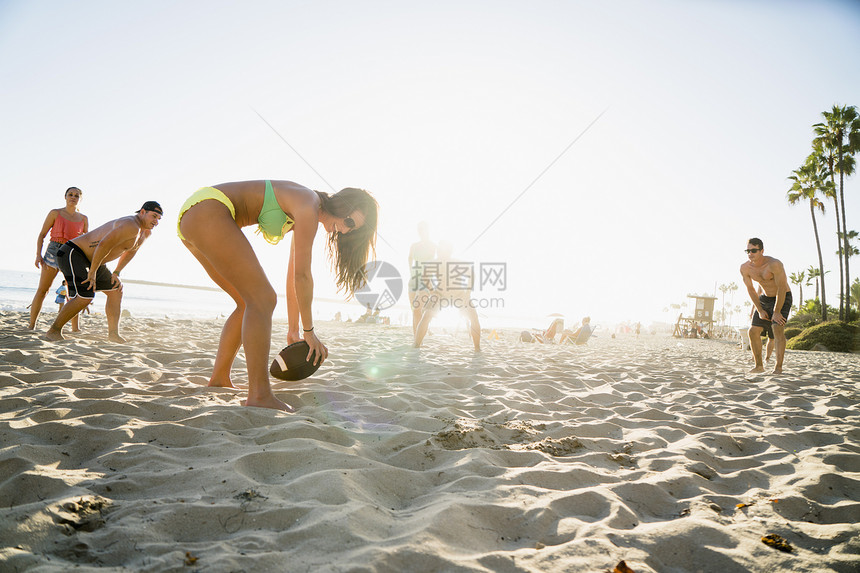 在美国加利福尼亚州纽波特海滩玩美式橄榄球的成人朋友图片