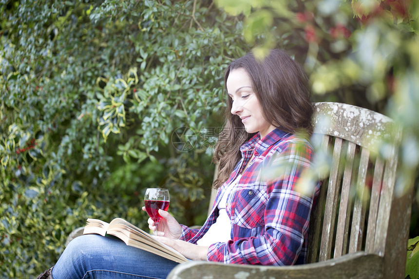 在城堡花园长椅上阅读的青年女性图片