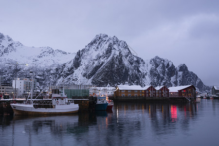 黄昏时的海滨港口和渔船斯沃尔瓦尔罗弗敦群岛挪威图片