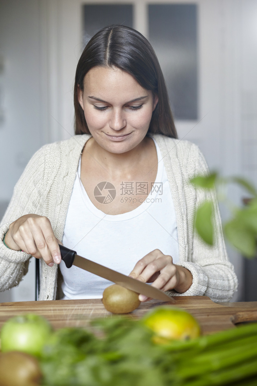 在厨房切菜的年轻女性图片