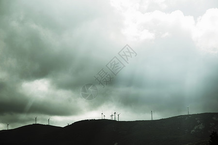 意大利撒丁岛科斯塔斯梅拉尔达暴风雨天空下的风电场低角度视图图片