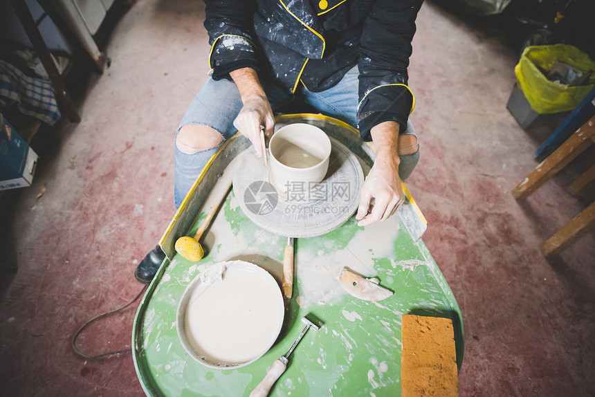 成年男子在陶瓷轮上做锅的图片