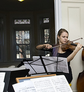 女青年在弦四重奏练习中拉小提琴高清图片
