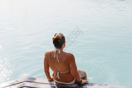 中成年妇女穿着比基尼坐在冰岛蓝湖温泉码头图片