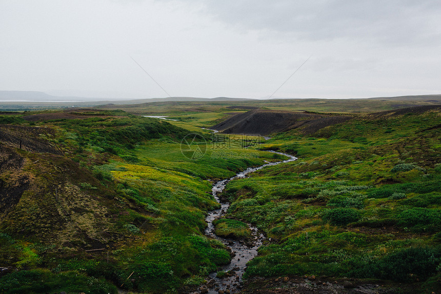 河风穿过平淡的绿田冰岛图片