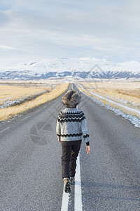 冰岛乡村道路中间行走的妇女图片