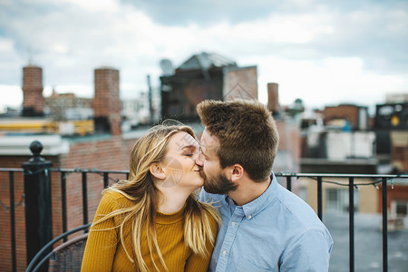 浪漫的年轻夫妇在城市屋顶露台接吻图片