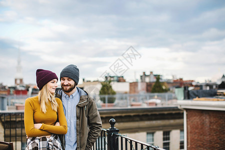 站在屋顶露台的年轻情侣图片