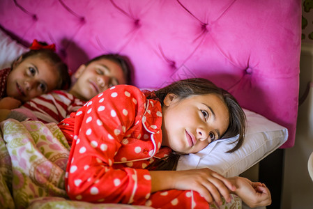 男孩和两个姐妹在睡觉图片