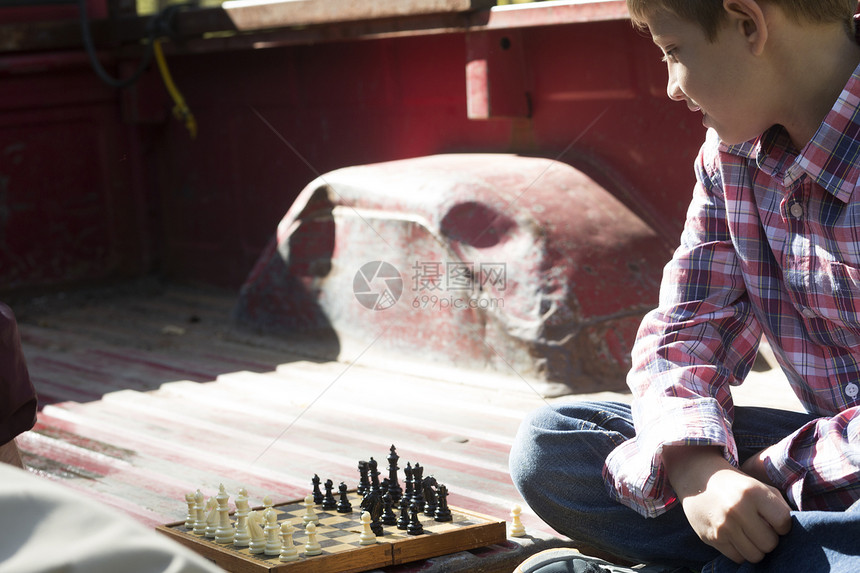 男孩在皮卡车后斗上下象棋图片