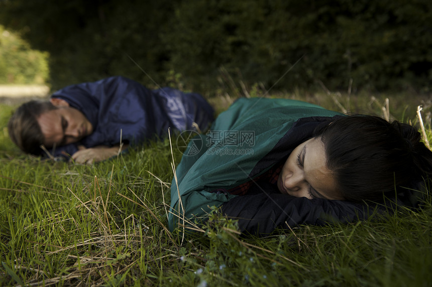 在野外睡袋中觉的年轻夫妇图片