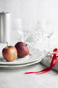 在盘上餐巾纸绑有红丝带的苹果图片