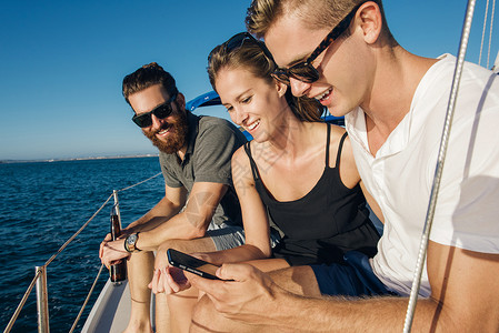 在帆船上使用智能手机的夫妇图片