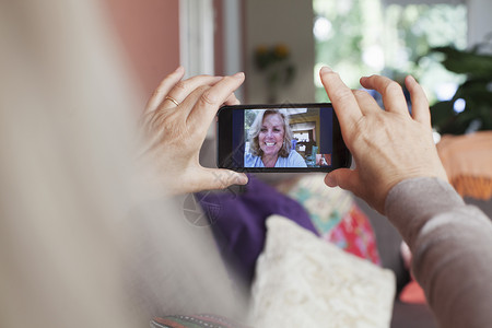 高级女性拿着智能手机和朋友通过视频对话图片
