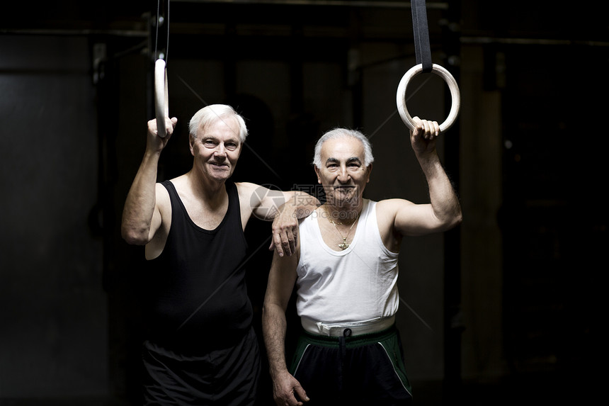 健身房里两名高年男子拿着健身环的肖像图片