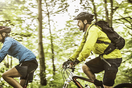 成熟的山地自行车情侣在森林里快速骑自行车图片