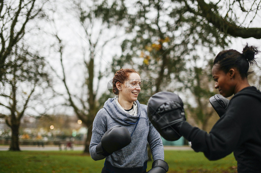 在公园中培训年轻成女拳击手图片