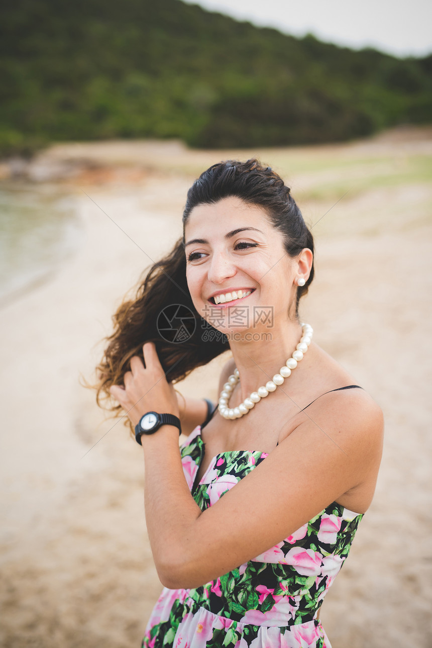 女人在海滩上手牵头发图片