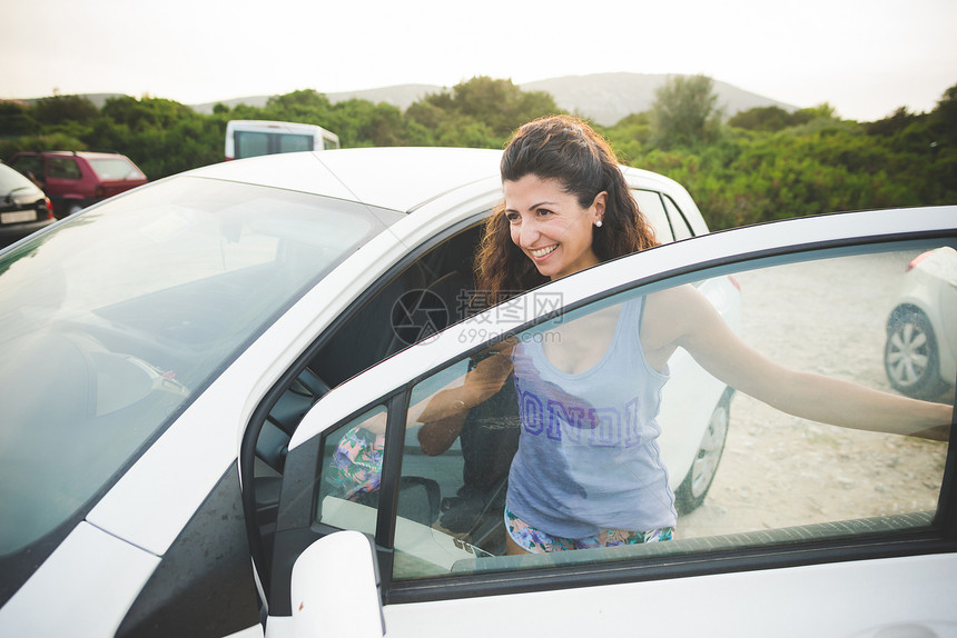 快乐的女人在海岸上车图片